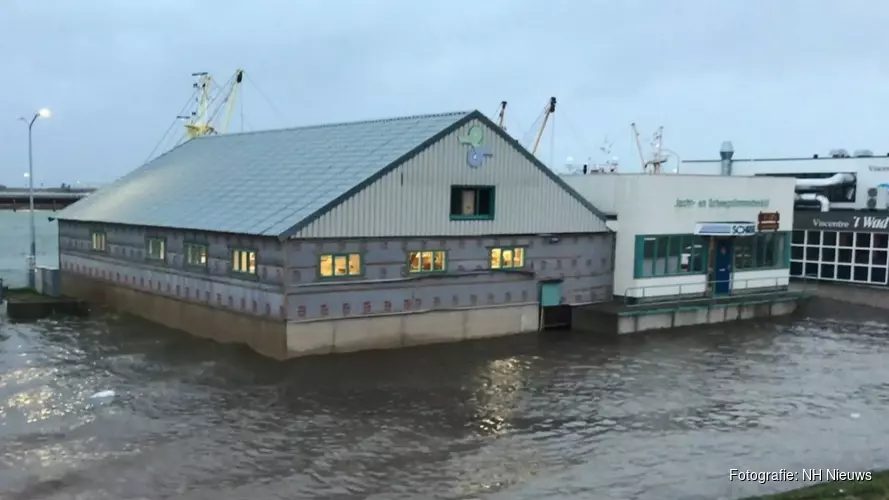 Klotsend water overspoelt kade in Den Oever